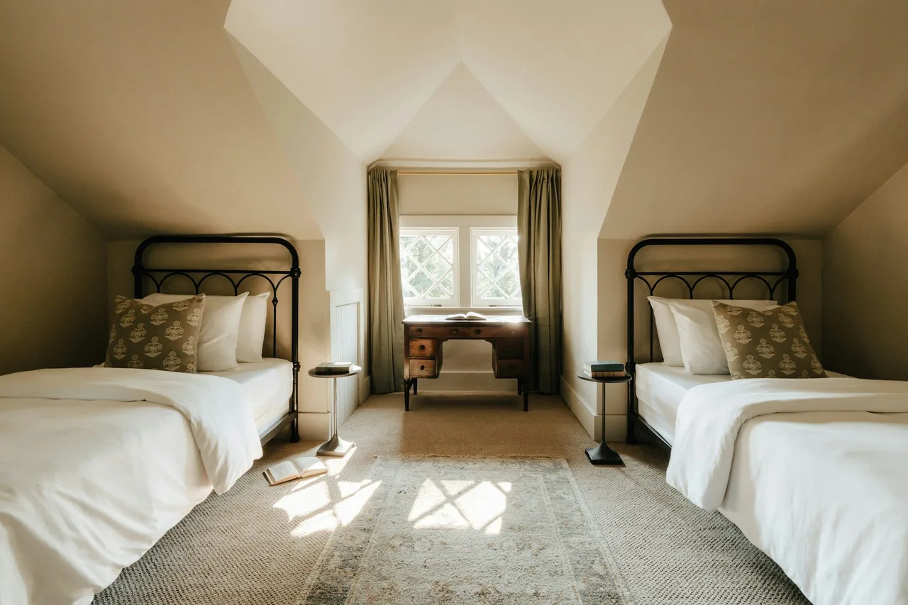 Stock illustration of a bedroom beneath sloping ceilings with a dormer window and natural light.