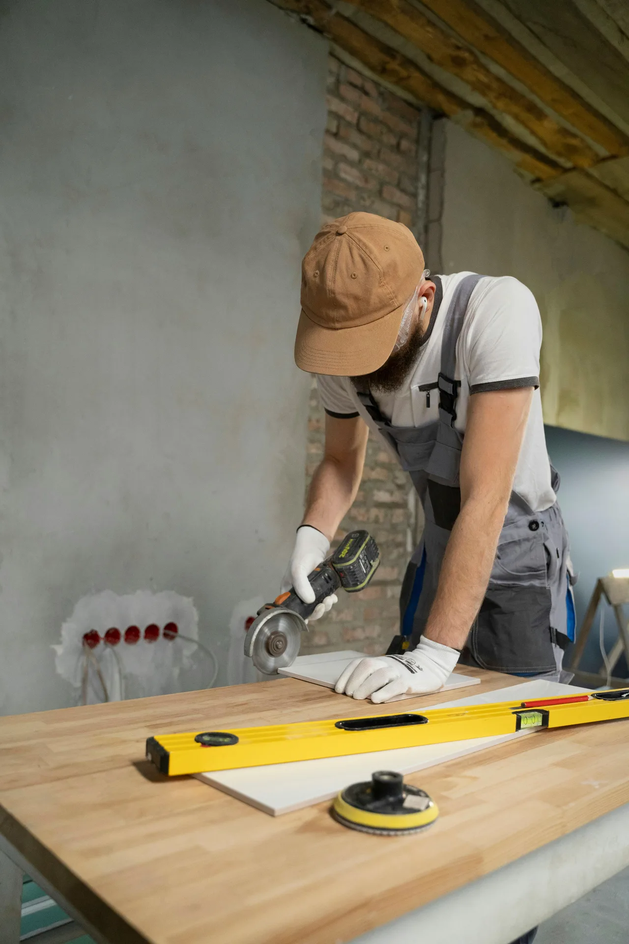 Stock photograph of a tradesperson cutting a tile during interior refurbishment.